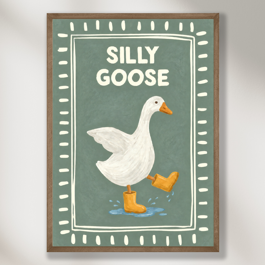Nursery art of a white goose in orange rain boots on a sage green background with a dotted border and the words Silly Goose